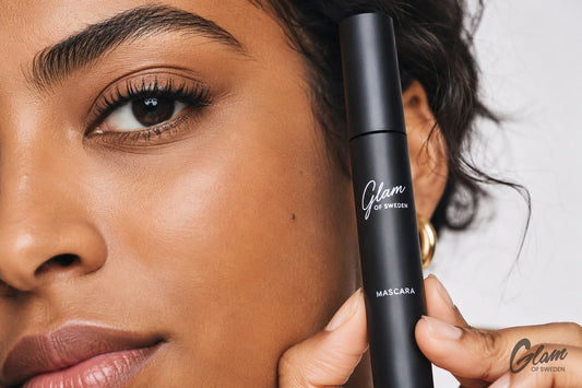 Femme marocaine aux cils volumineux tenant le mascara noir Glam of Sweden — Glam of Sweden Maroc